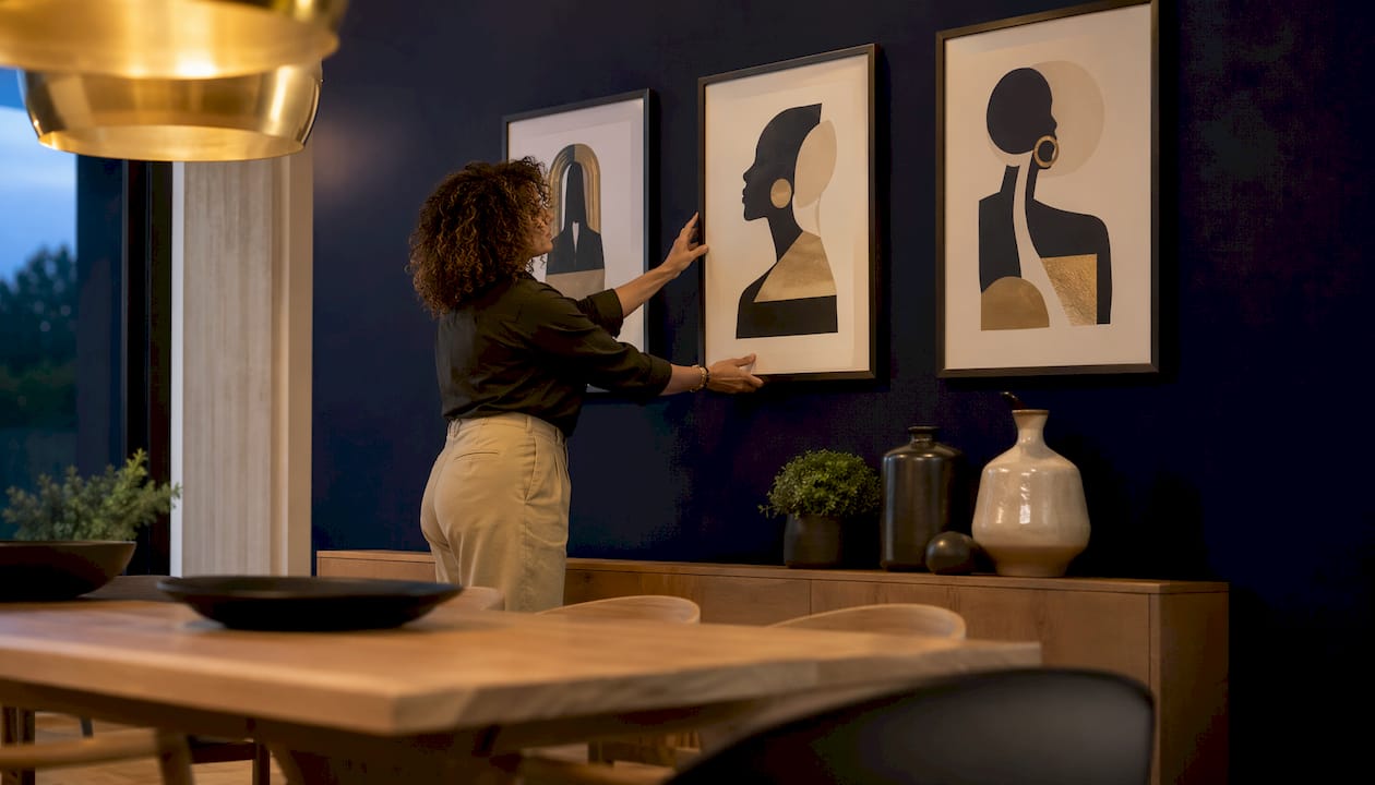 Woman arranging dining room wall art