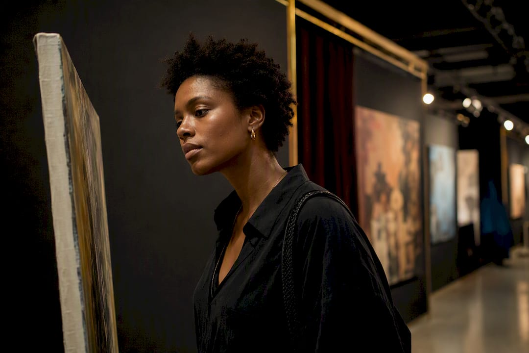Black art enthusiast browsing independent gallery booth