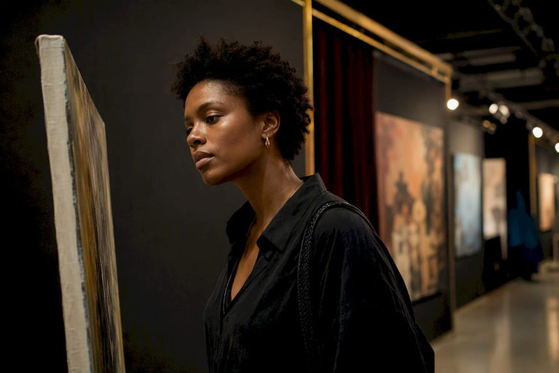 Black art enthusiast browsing independent gallery booth