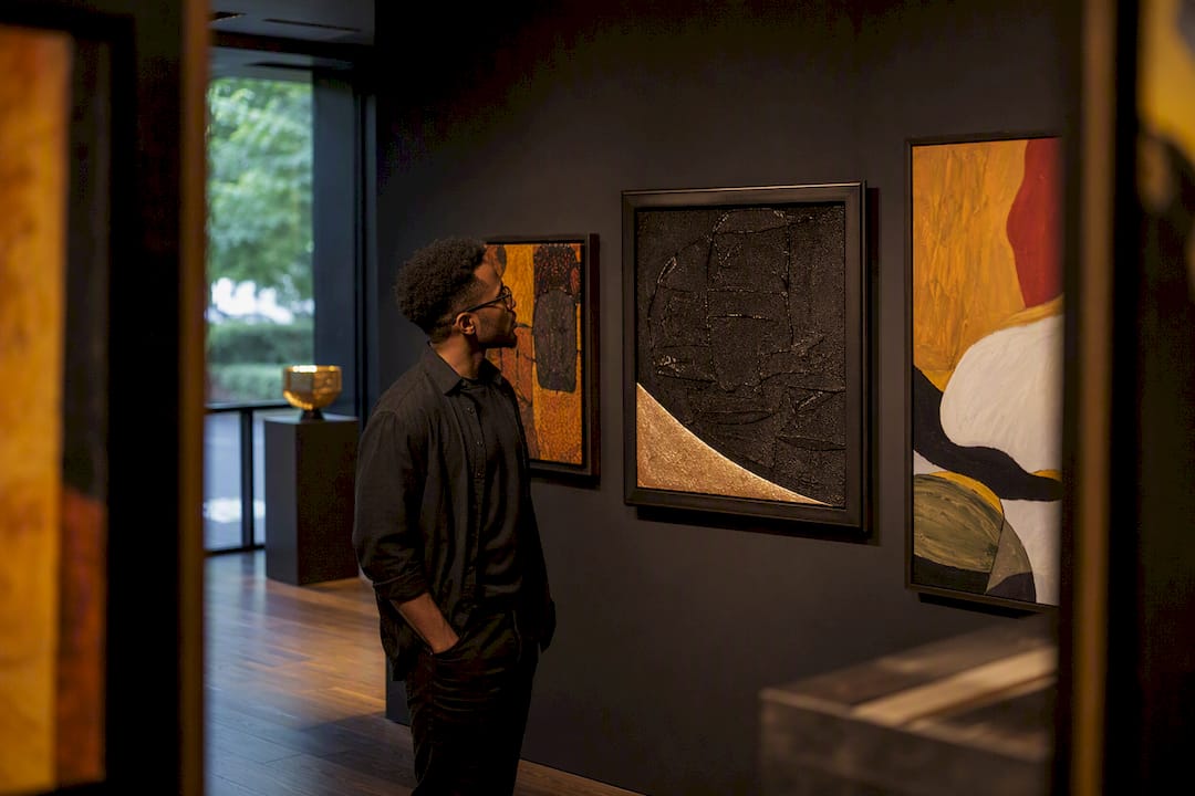 Buyer comparing Black art in gallery