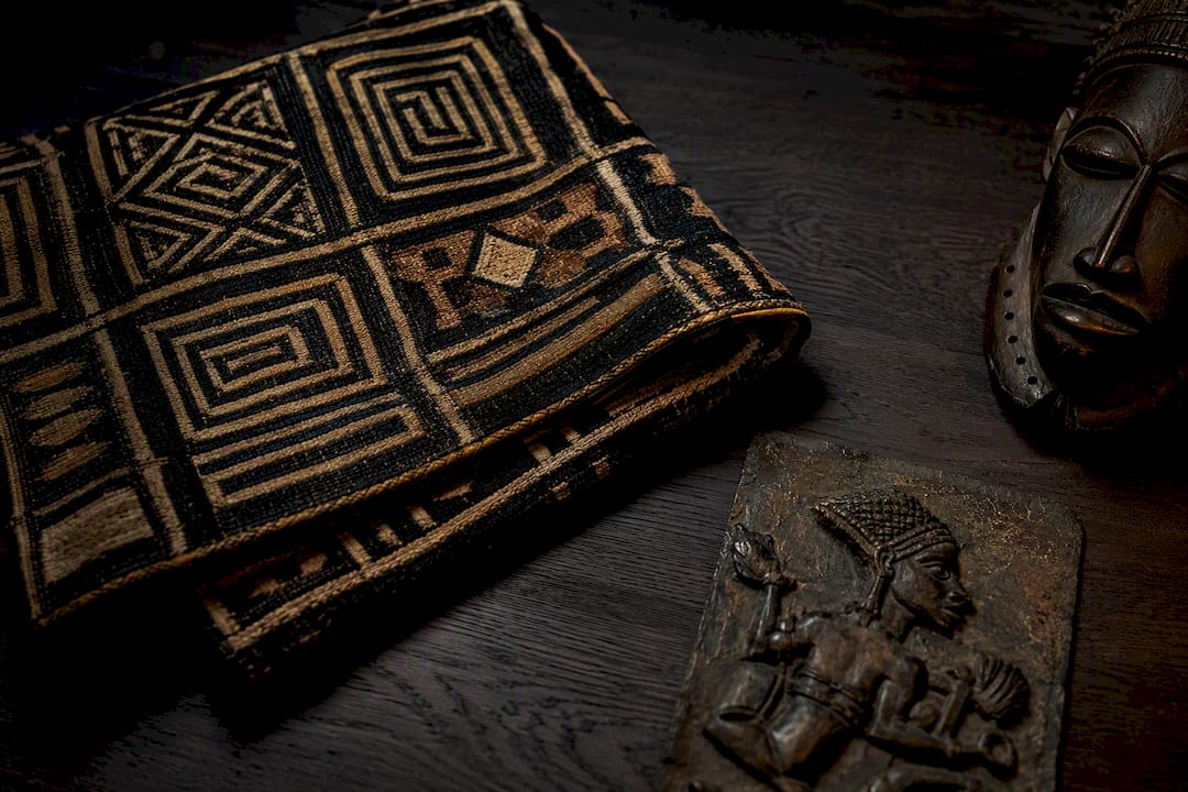 Kuba textile beside African art objects