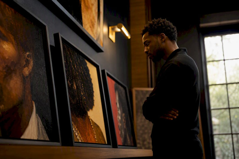 Collector viewing curated Black art pieces