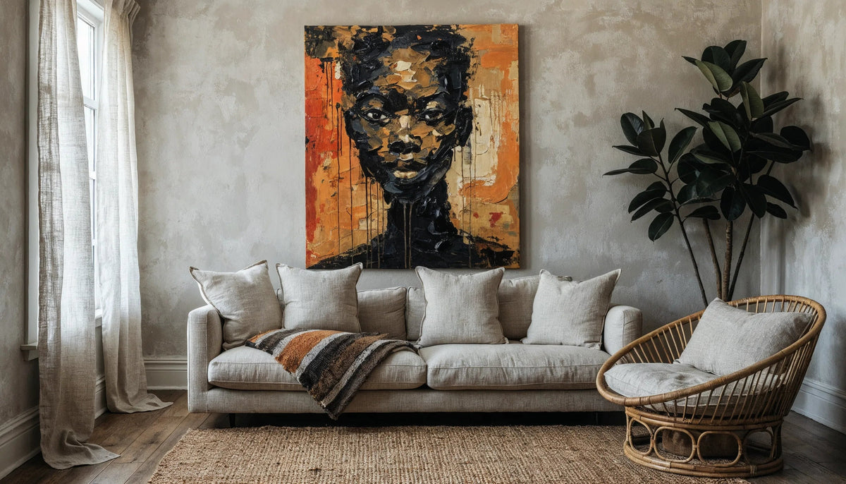 A wide view of a living room with warm greige walls, a linen sofa, a rattan chair, a jute rug, a tall floor plant and one large canvas above the sofa.