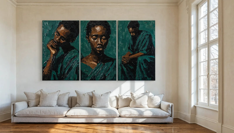 Three matching upright canvases hung as a triptych above a long low sofa on a tall pale wall