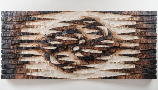 Relief print of repeated carved geometric shapes across a wide band, thickening at one point into an abstract mask form
