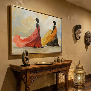 African wall decor in a warm hallway, gold framed gown painting beside carved masks and a glowing Moroccan lantern