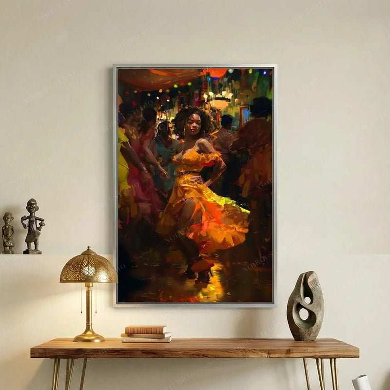Melanin art canvas of a woman salsa dancing in orange, silver frame above a wood console with a brass lamp