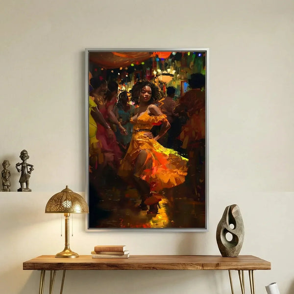 Melanin art canvas of a woman salsa dancing in orange, silver frame above a wood console with a brass lamp