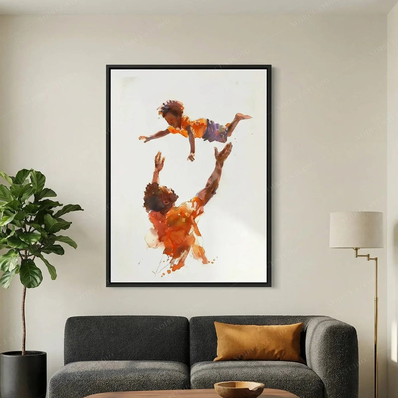 Black art for living room, black-framed father and son watercolor above a charcoal sofa beside a fiddle leaf fig