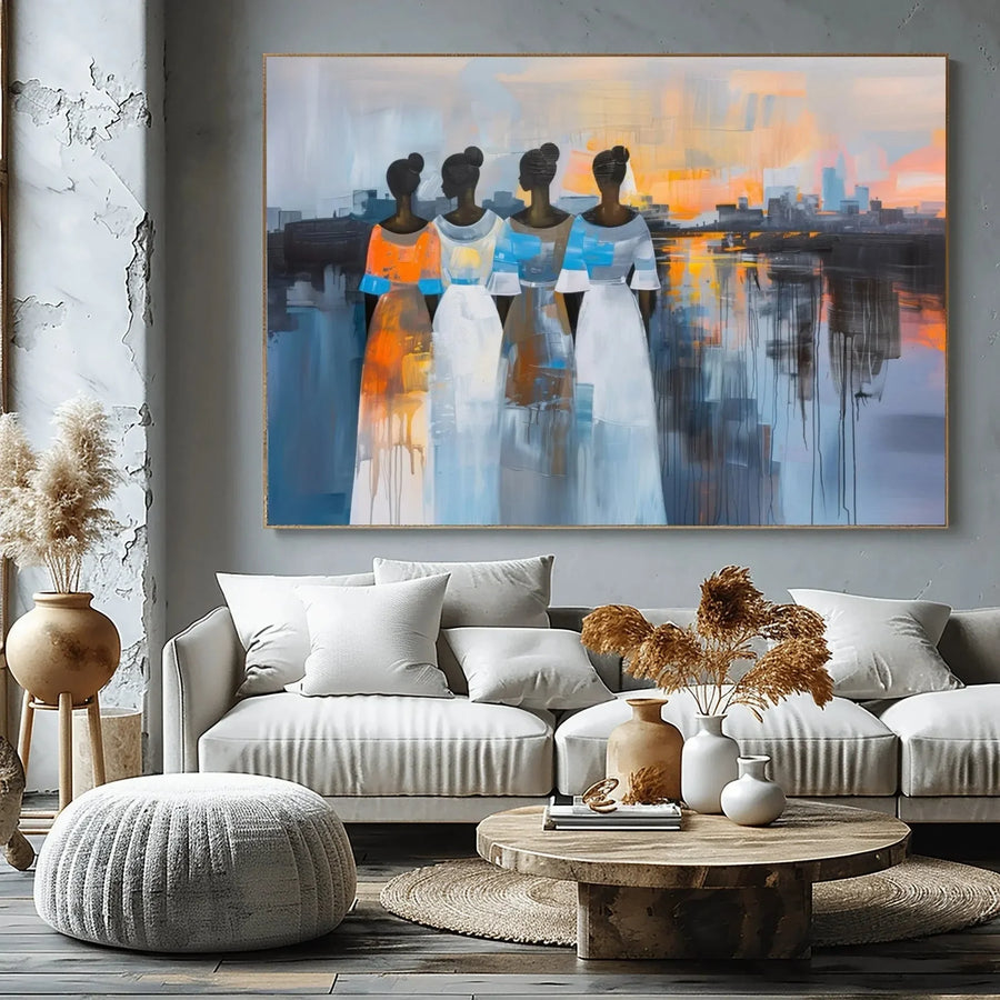Black art for living room, four women at sunset above a greige sectional with pampas grass and a round wood table