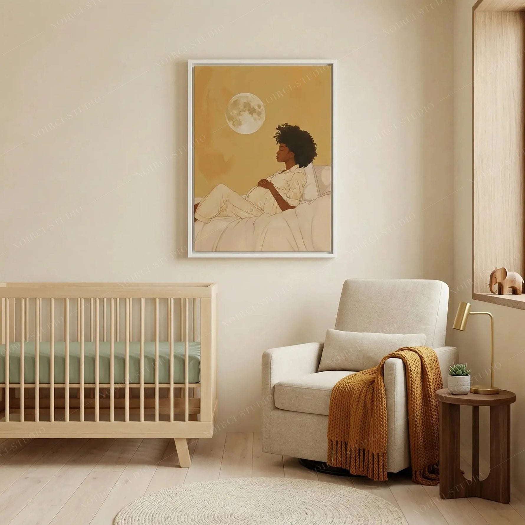 Black art for nursery walls, moon maternity print in a white frame above a boucle glider and wooden crib