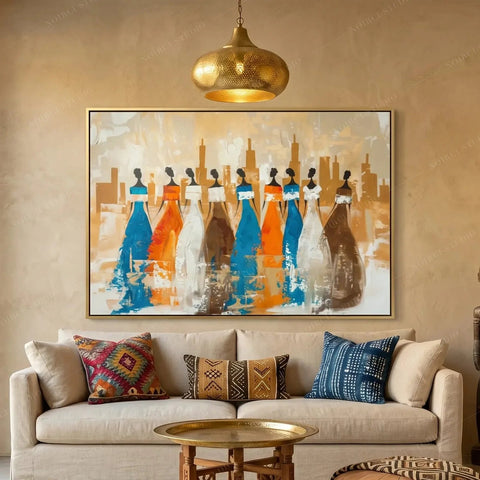 Ancestors African village wall art canvas featuring nine tribal women in blue and orange gowns, above a cream sofa in a Moroccan plaster living room