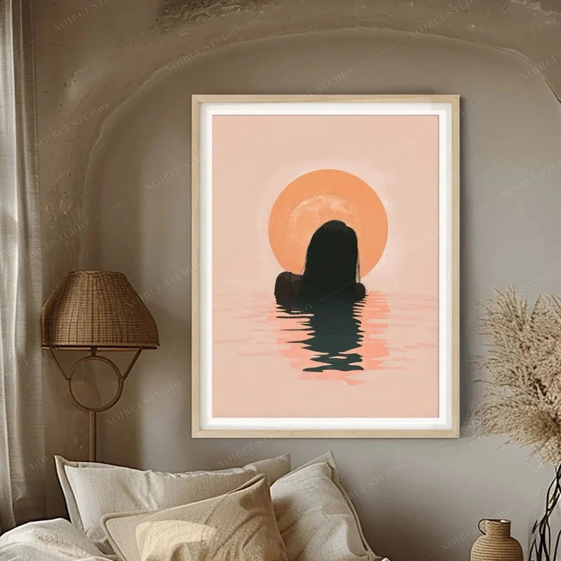 Black art for the bedroom, peach sunrise canvas in a light wood frame above cream pillows in a plaster arch nook