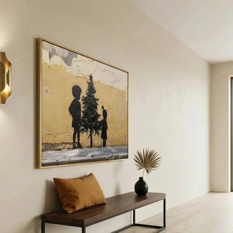 Black art for an entryway, gold-framed Christmas mural print above a dark wood bench with a mustard pillow