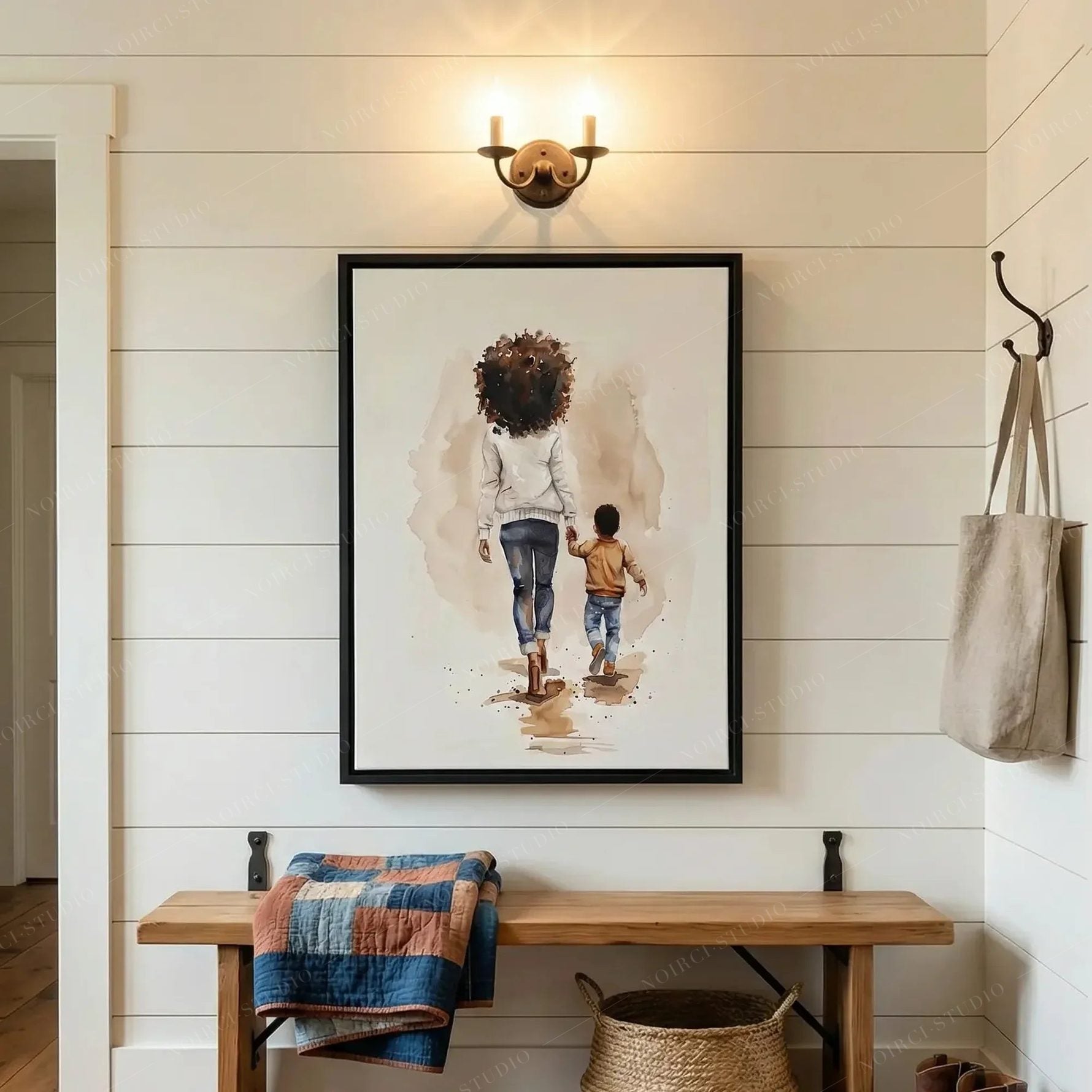 Black family wall art in a shiplap entryway with brass sconce, wood bench and denim quilt, mother and son watercolor