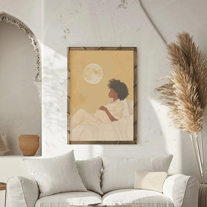 Afrohemian decor, moon maternity art in a wood frame beside pampas grass and an arched nook in a white boho living room