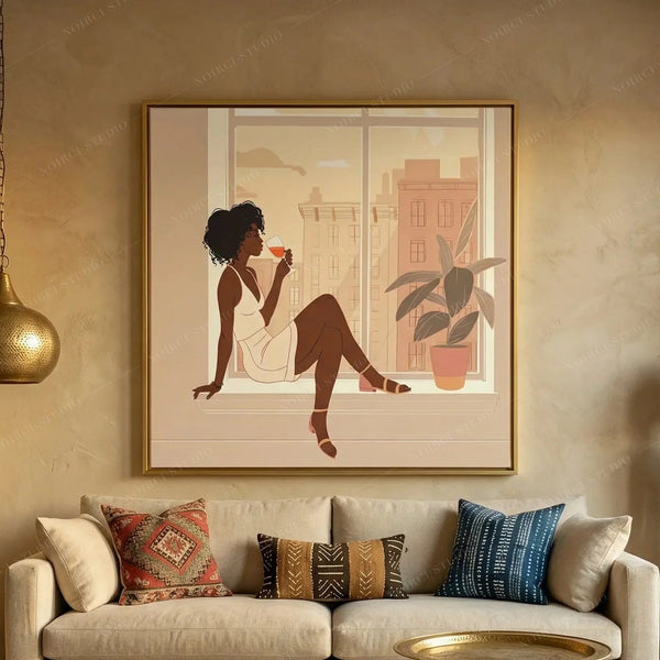 Black woman wine art in a gold frame above a beige sofa with kilim and mudcloth pillows, woman sipping wine at a city window