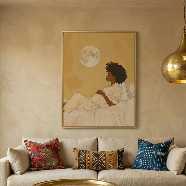 Black maternity wall art above a cream sofa with mudcloth pillows, pregnant Black woman resting under a full moon