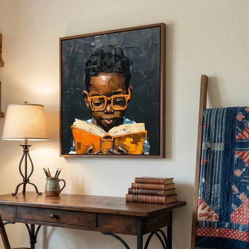 African American boy reading wall art above a writing desk and books in a home office