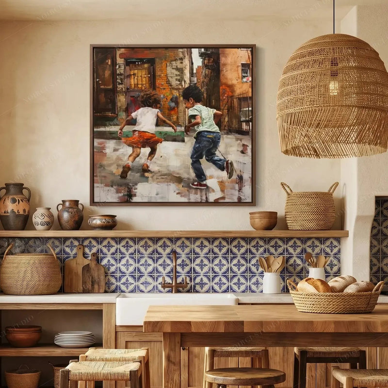 Black kitchen wall art above blue Spanish tile, kids-at-play painting beside a rattan pendant and wood shelving