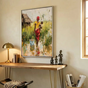 African American art for a home office, mother carrying baby painting above a wood desk with carved statues