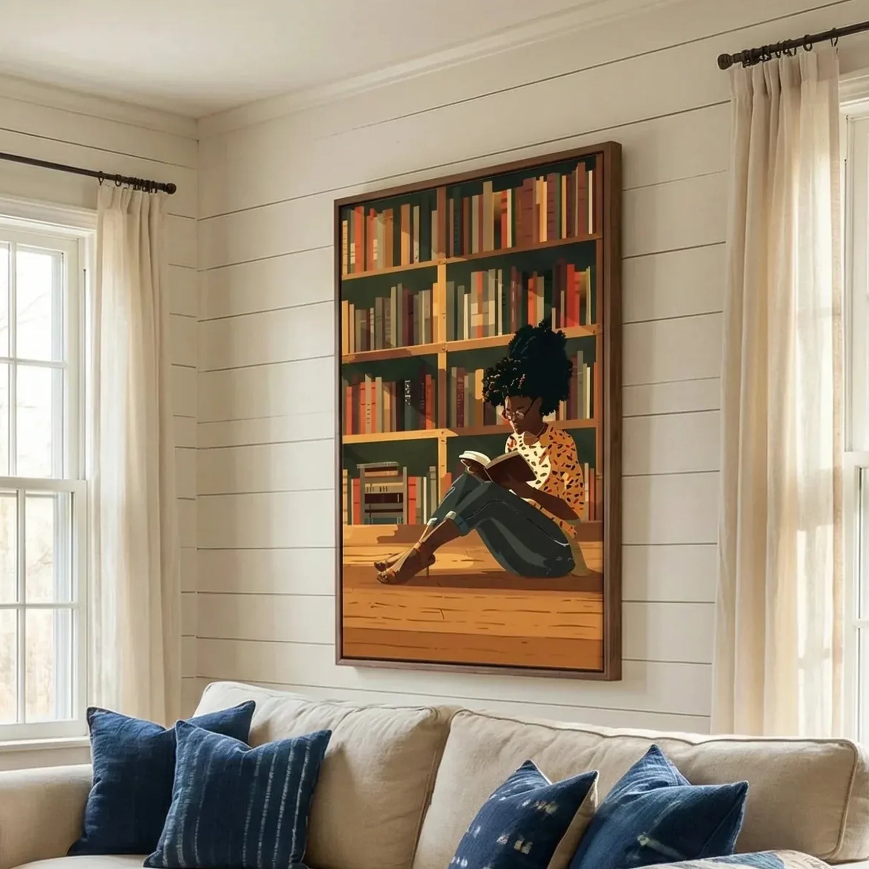 Black art for living room, girl reading canvas above a cream sofa with indigo pillows on a shiplap wall
