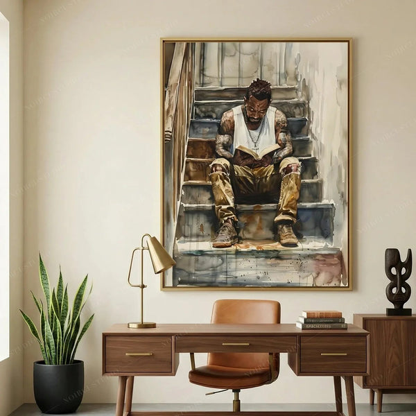 Harlem Renaissance art above a walnut desk and snake plant in a home office, watercolor of a Black man reading on stairs