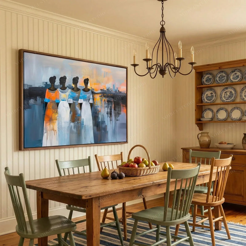 Framed painting of four women at sunset in a cottage dining room with sage Windsor chairs and a china hutch