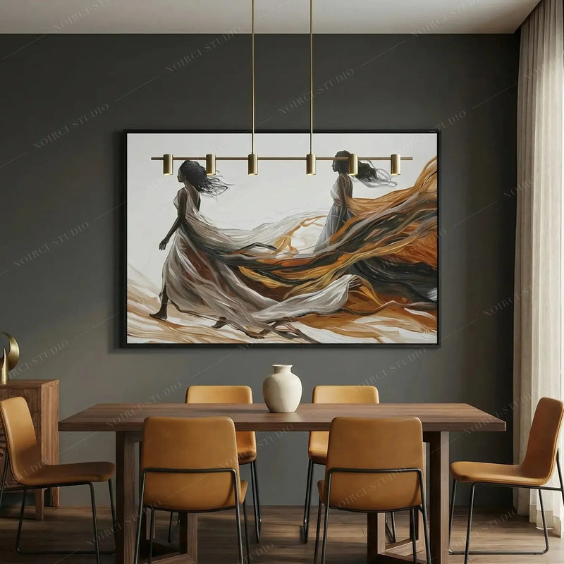 African canvas art in a modern dining room with amber chairs, two women trailing golden fabric under brass pendants