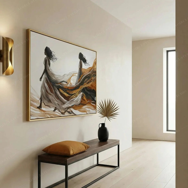 Modern Black art in a bright hallway, two women with sweeping amber trains above a dark bench with a mustard pillow