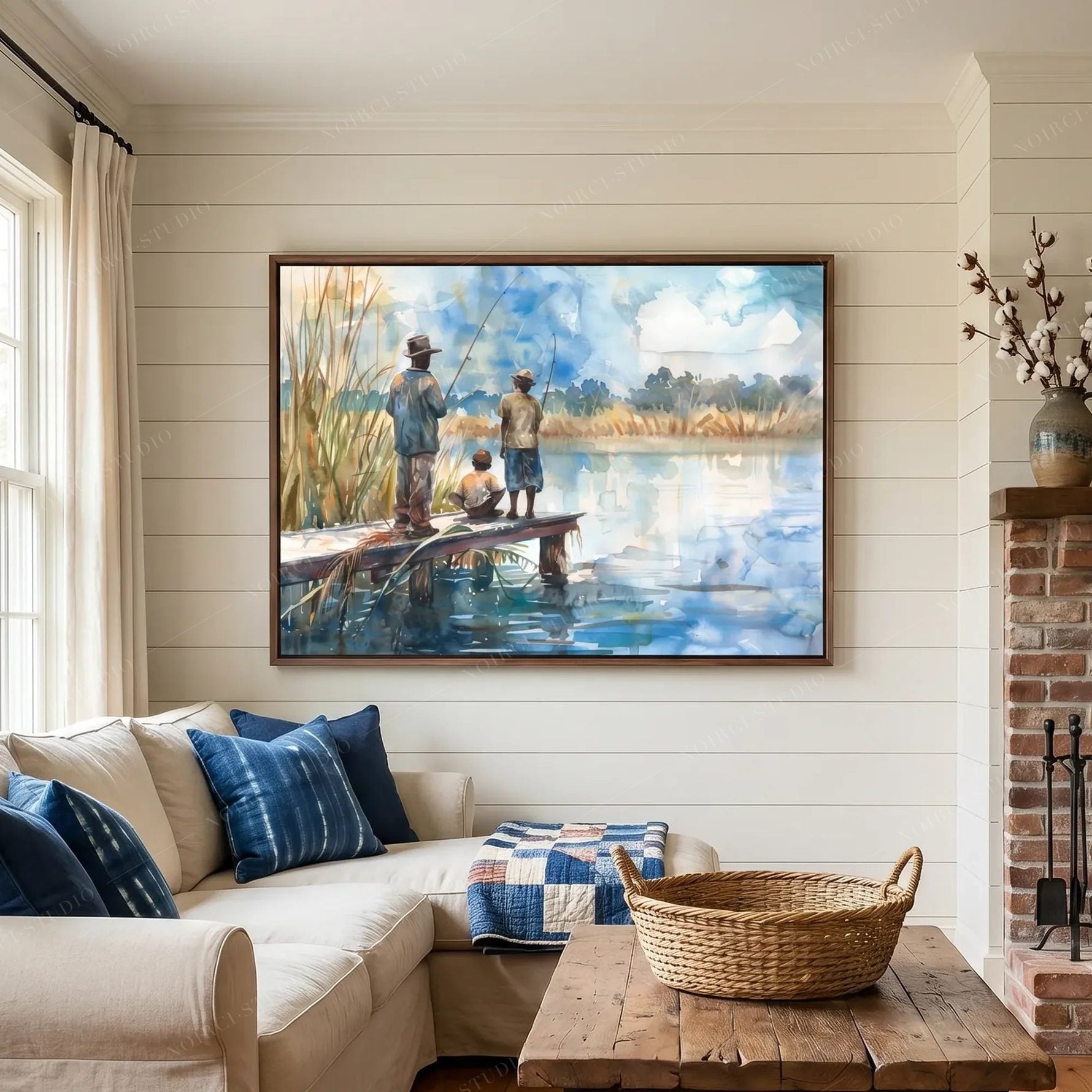 Black art for living room walls, watercolor of a fishing dock above a cream sectional with indigo pillows