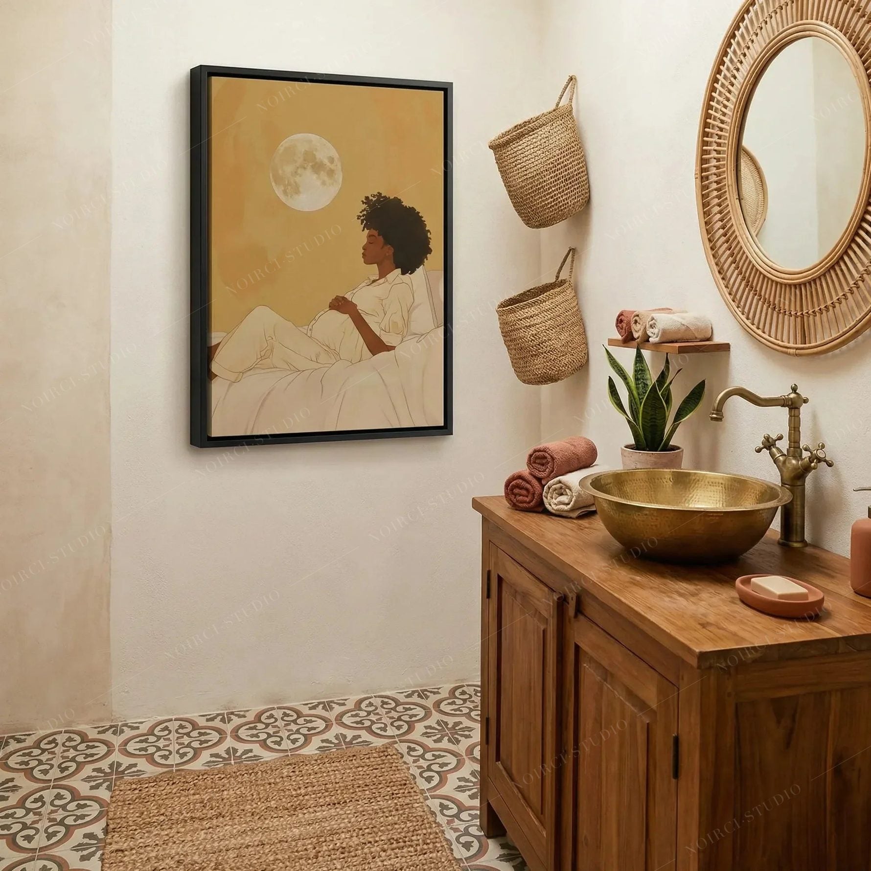 Black bathroom wall art, moon maternity canvas in a black frame above patterned tile, brass basin and wood vanity