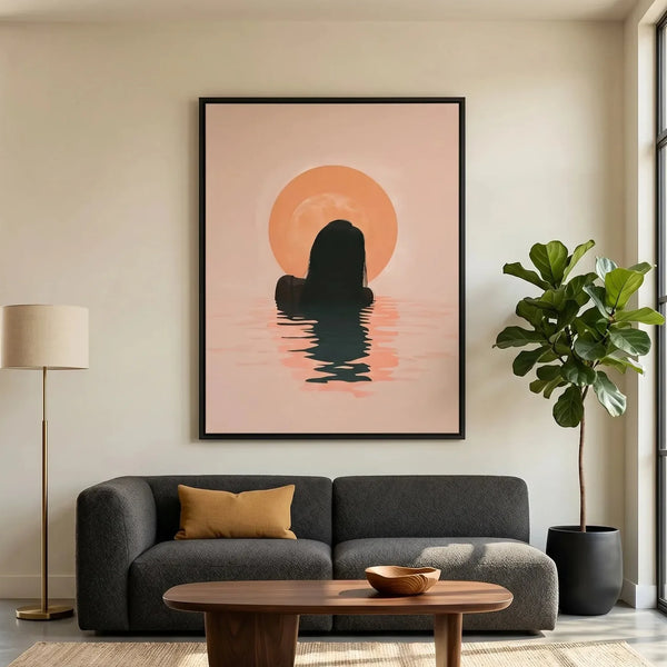 Black woman sunrise wall art in a black frame above a charcoal sofa, silhouette rising from calm water at first light