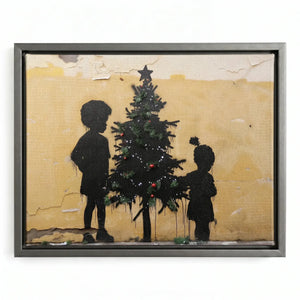 Black art Christmas canvas in a silver floating frame, kids adding red ornaments to a graffiti Christmas tree