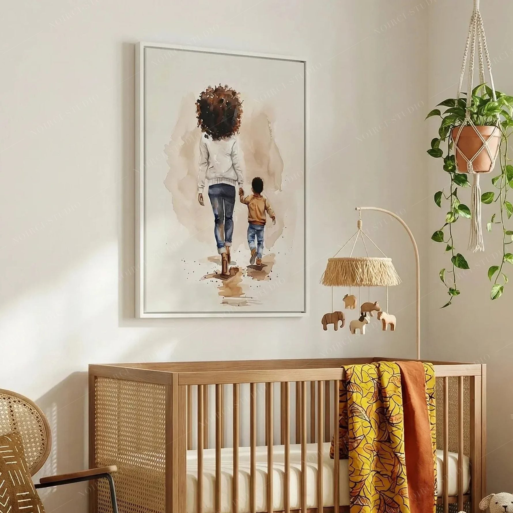 Black art for nursery walls, white-framed mother and son watercolor above a cane crib with yellow wax print blanket