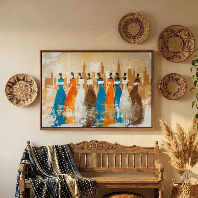 Ancestors African village wall art in a walnut frame above a carved entryway bench with mudcloth throws and woven baskets
