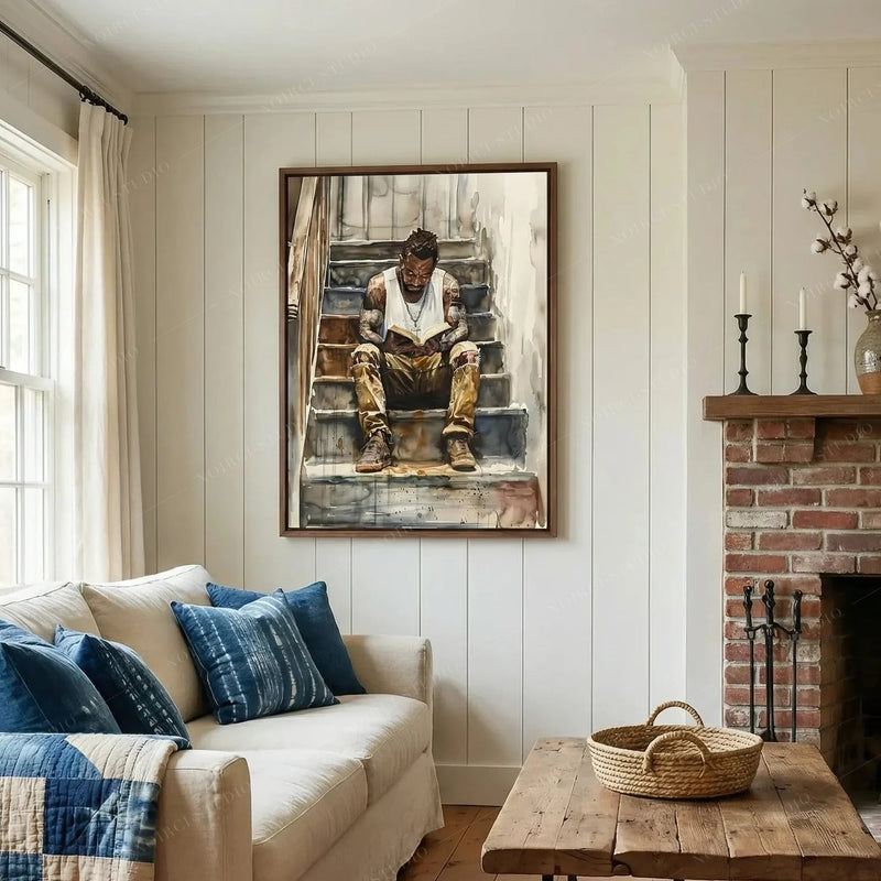 African American wall art in a shiplap living room with brick fireplace and blue pillows, man reading watercolor