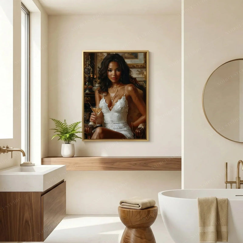 Black bathroom wall art in a gold frame above a wood vanity, round brass mirror, and freestanding tub in a cream bath