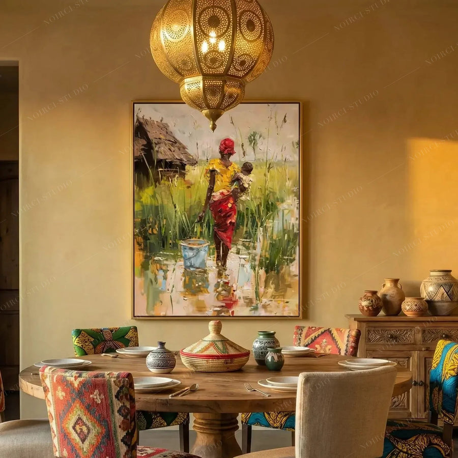African village painting of a mother and baby above a Moroccan dining table with a brass lantern and carved chairs