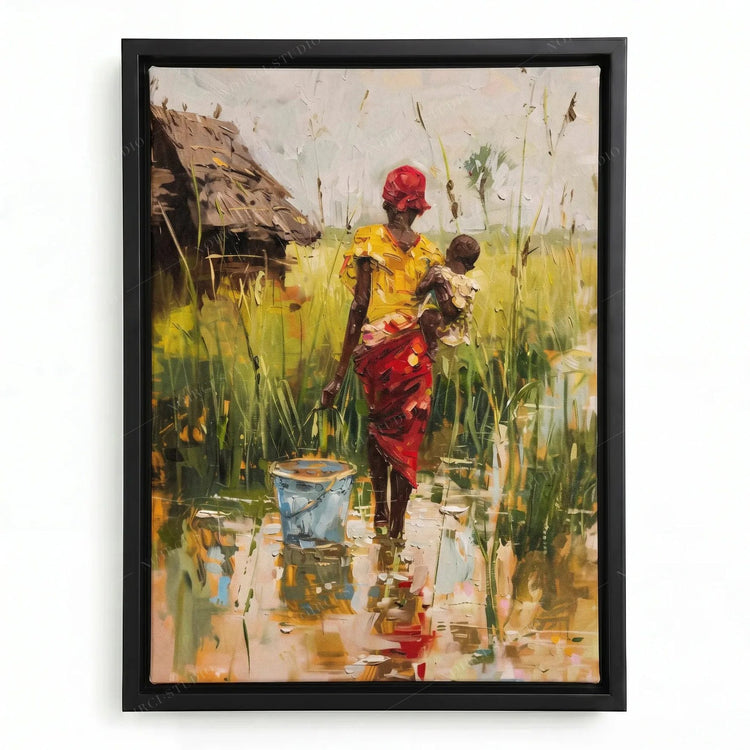 African canvas art in a black floating frame, mother in yellow and red carrying her baby past a thatched hut