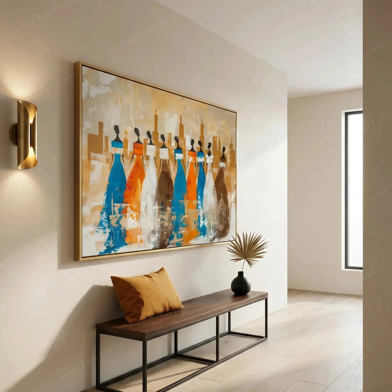 Ancestors tribal women wall art in a gold frame above an apartment hallway bench with mustard pillow